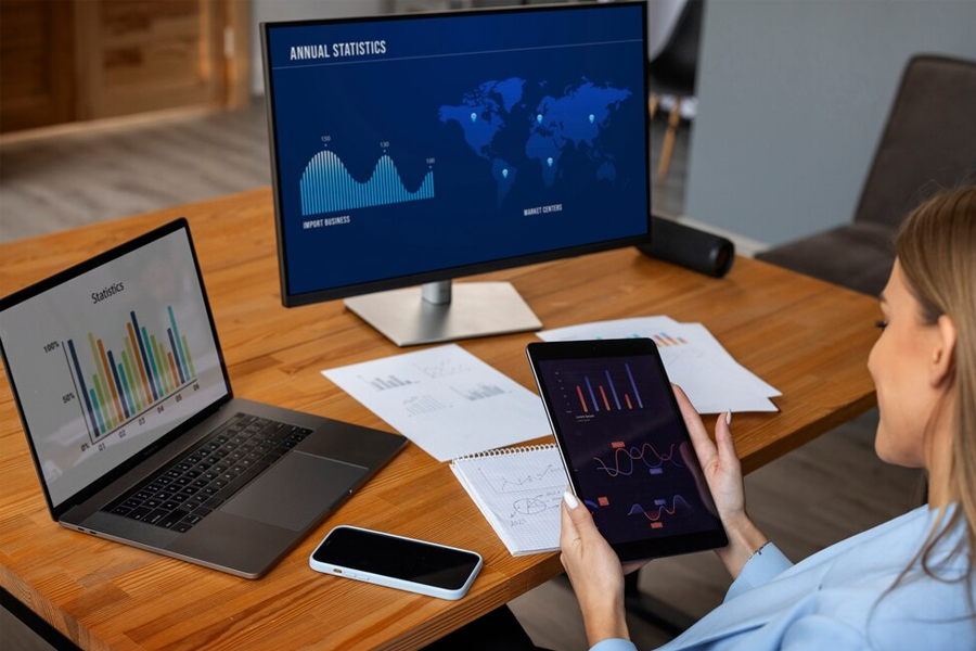 a woman sitting at a desk with a computer compares analyses