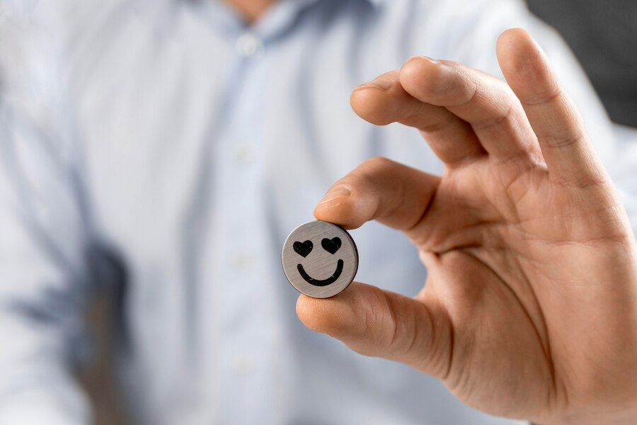 person holding a token with a smiley face on it