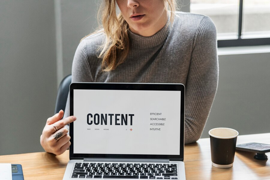 person pointing to a laptop saying "content" as an example of types of CMS