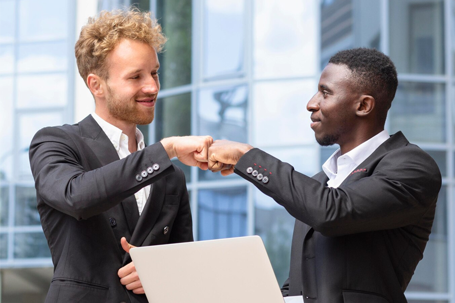 two people in suits bumping fists